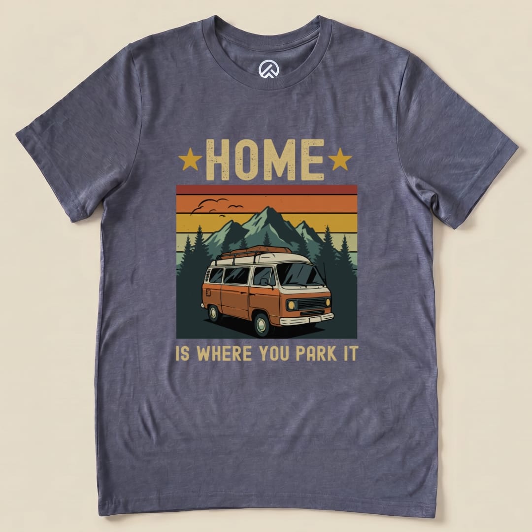 The graphic t-shirt features an orange van amidst mountains and trees, with the phrase "Home Is Where You Park It" prominently displayed.