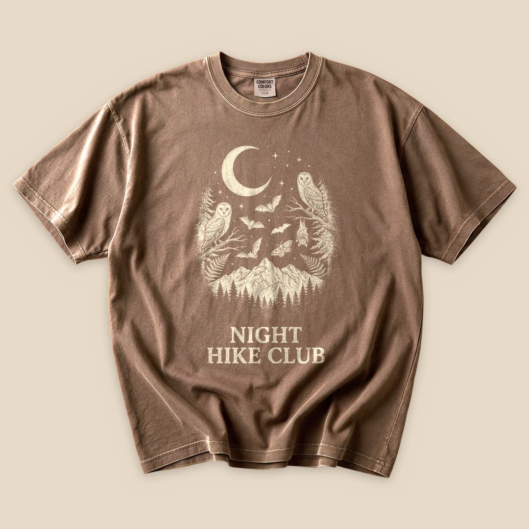Brown graphic t-shirt featuring the slogan "NIGHT HIKE CLUB" with a design of mountains, a crescent moon, and owls.