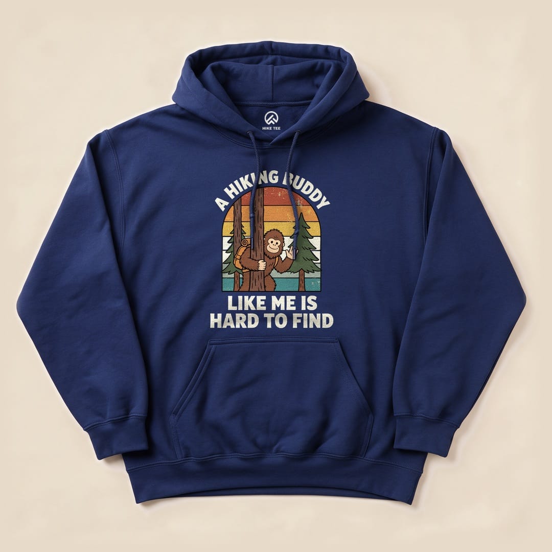 A navy hoodie featuring a graphic of a playful monkey behind a tree with the slogan "A Hiking Buddy Like Me Is Hard To Find.
