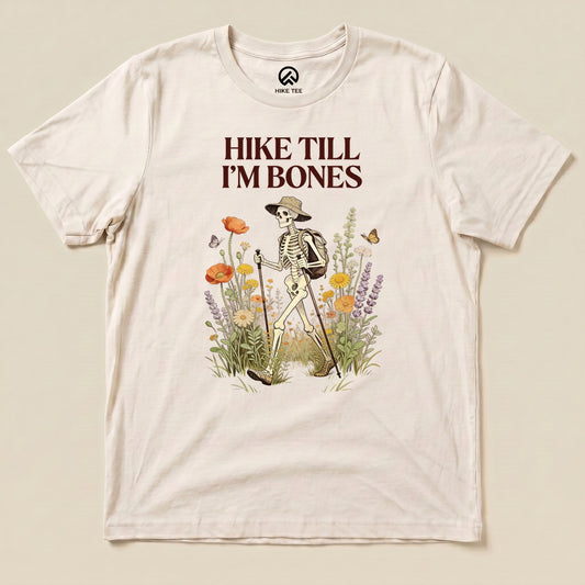 Natural Hike Till I'm Bones Shirt with a skeleton hiker walking through wildflowers graphic