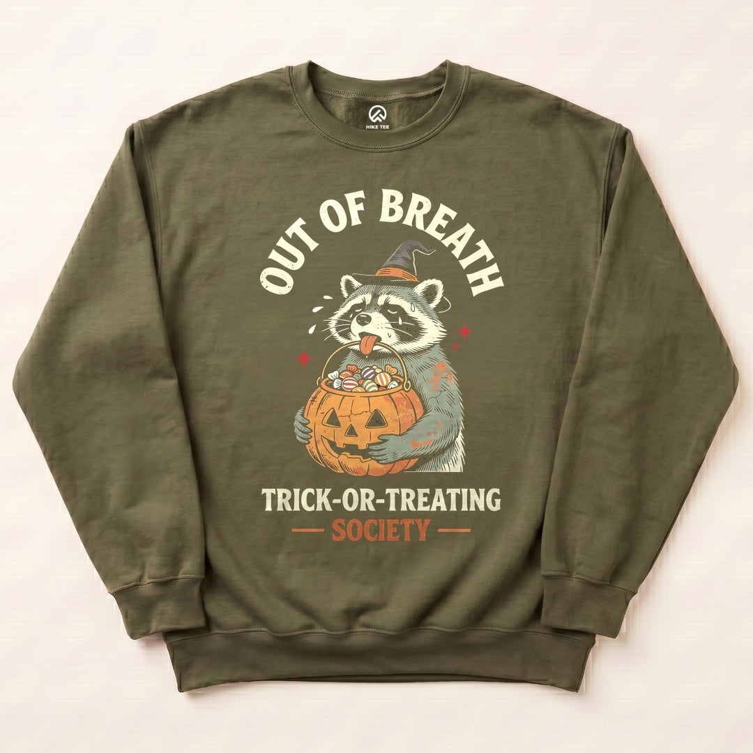 Military Green Out of Breath Trick-or-Treating Society Sweatshirt with a tired raccoon holding a jack-o-lantern candy bucket graphic