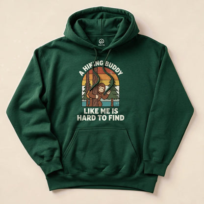 A green hoodie featuring a graphic of a playful monkey among trees, with the text "A Hiking Buddy Like Me Is Hard To Find.