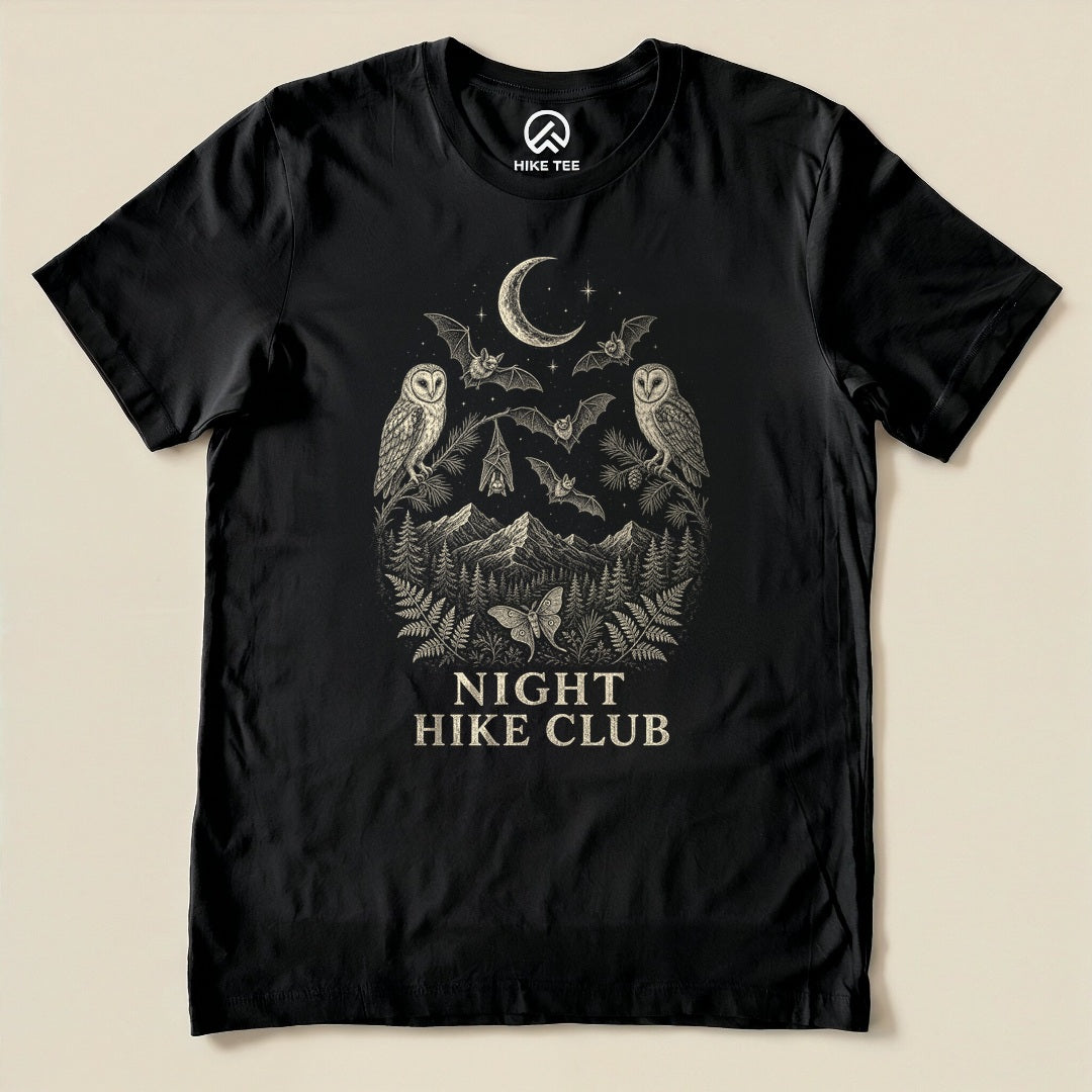 Black Night Hike Club Engraved Shirt with a night forest scene with a moon, owls, moths and mountains in engraved style graphic