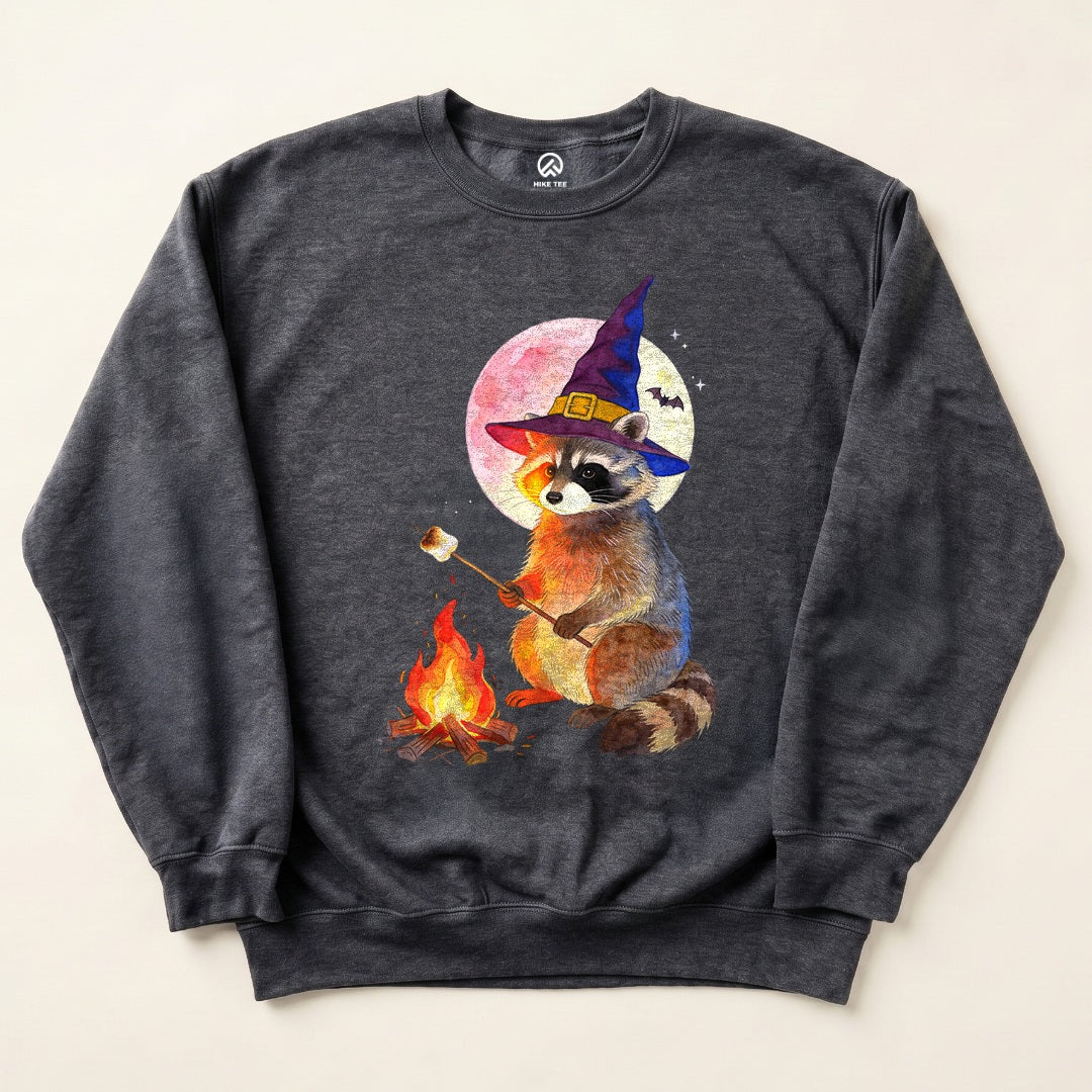 Dark Heather Raccoon Witch Campfire Sweatshirt with a raccoon in a witch hat roasting a marshmallow by the campfire graphic