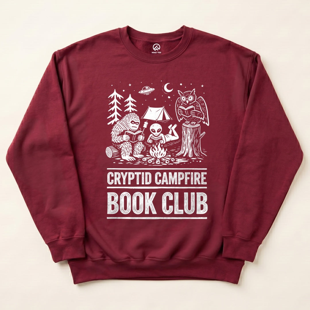 Maroon Cryptid Campfire Book Club Sweatshirt with a Bigfoot and friends reading around a campfire graphic
