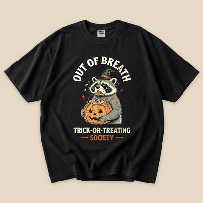 Black Out of Breath Trick-or-Treating Society T-Shirt with a raccoon with a jack-o'-lantern trick-or-treating graphic