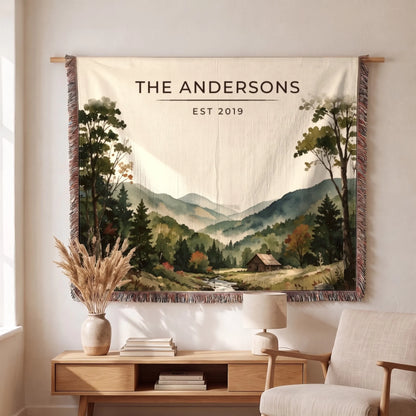 Personalized Great Smoky Mountains Cabin Woven Blanket hanging on a living room wall, family name and year woven in