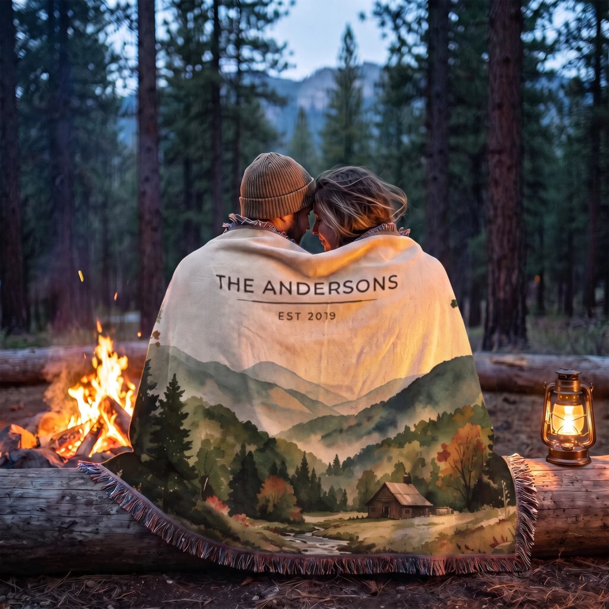 Couple wrapped in the personalized Great Smoky Mountains Cabin Woven Blanket by a campfire