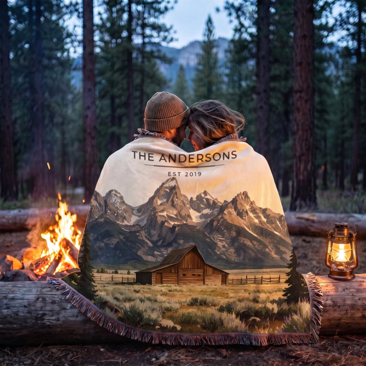 Couple wrapped in the Grand Teton Barn Woven Blanket by a campfire