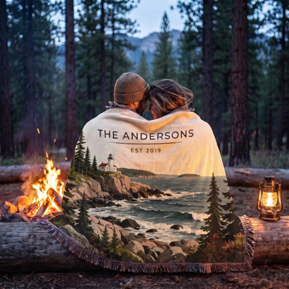 Couple wrapped in the Acadia Lighthouse Coast Woven Blanket by a campfire