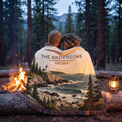 Couple wrapped in the Acadia Lighthouse Coast Woven Blanket by a campfire