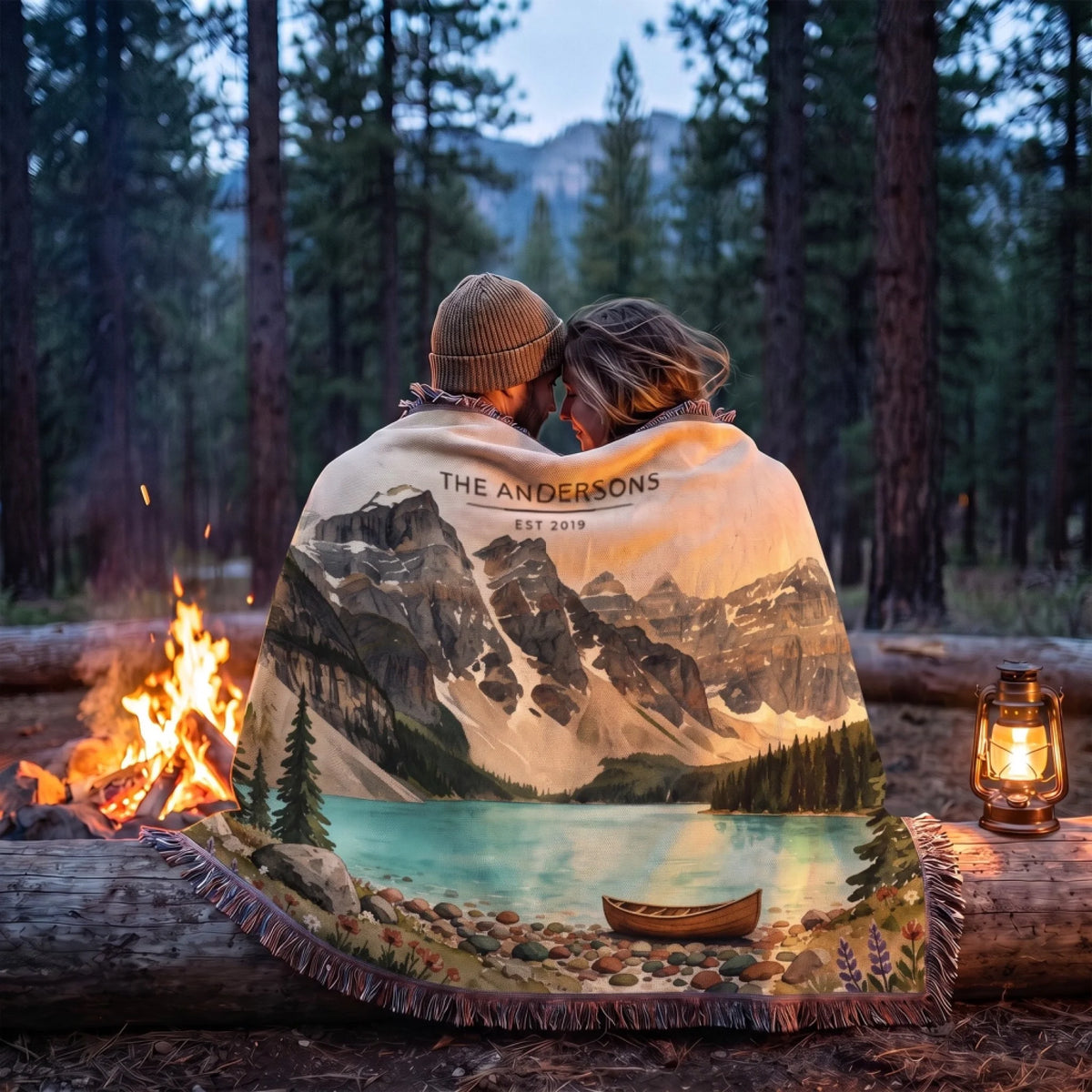 Couple wrapped in the Glacier Lake Canoe Woven Blanket by a campfire