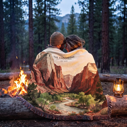 Couple wrapped in the Zion Canyon River Woven Blanket by a campfire