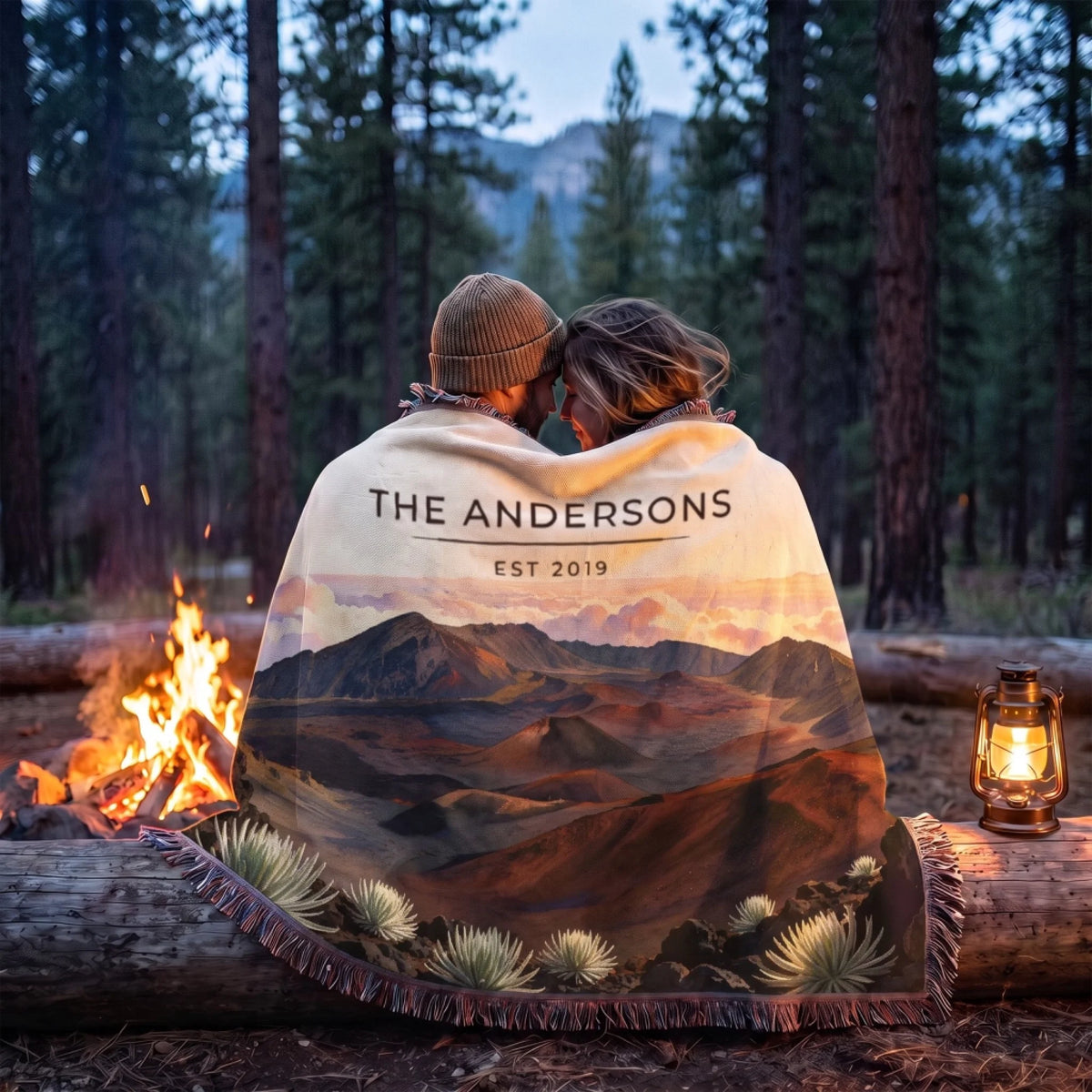 Couple wrapped in the Haleakala Crater Sunrise Woven Blanket by a campfire