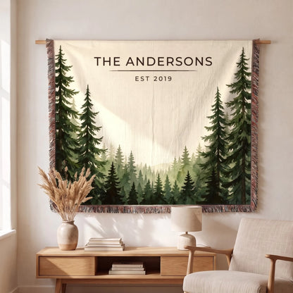 Personalized Evergreen Forest Treetops Woven Blanket hanging on a wall, family name woven in