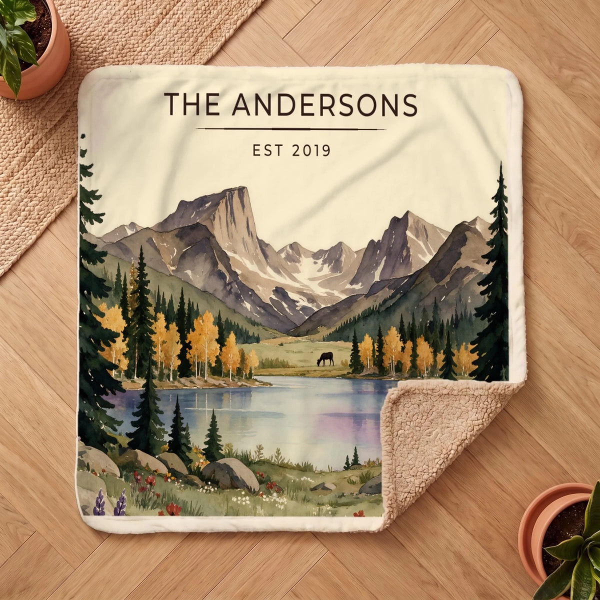Personalized Rocky Mountain Lake Elk Sherpa Blanket on a wooden floor with the cozy sherpa back showing