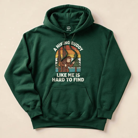 A green hoodie featuring a graphic of a playful monkey among trees, with the text "A Hiking Buddy Like Me Is Hard To Find.