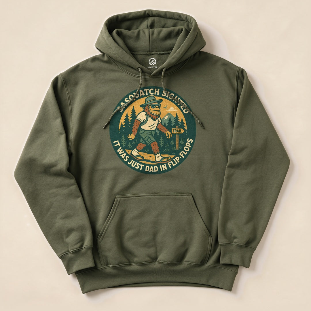 The Sasquatch Sighted Hoodie features a humorous graphic of Sasquatch walking on a trail, with the text "It was just Dad in flip-flops.