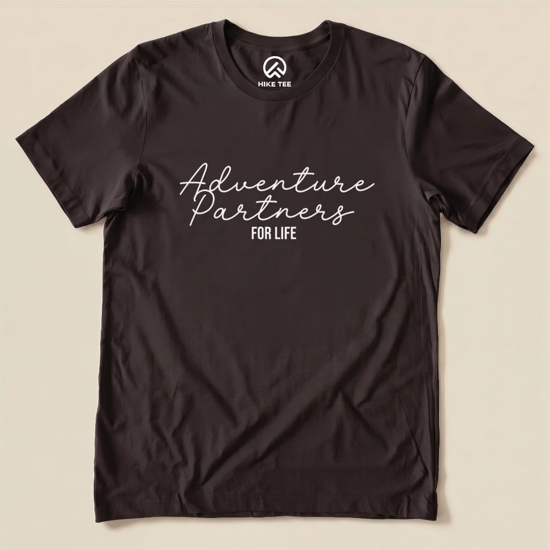 A flat view of the Adventure Partners Shirt, a graphic t-shirt featuring the phrase "Adventure Partners FOR LIFE" in stylish white font on a black background.