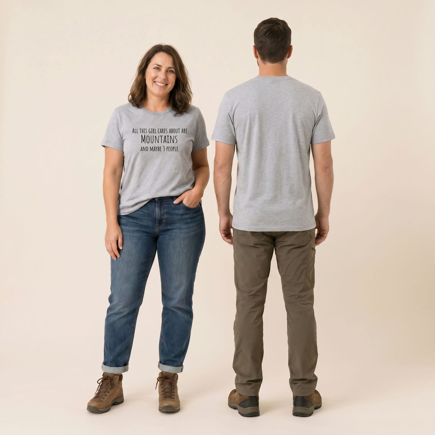 A woman smiling while wearing a gray graphic t-shirt that reads "All This Girl Cares About Are MOUNTAINS and maybe 3 people.