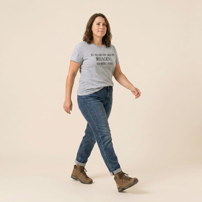A woman walks confidently in a light gray graphic t-shirt that reads "All This Girl Cares About Are Mountains and Maybe 3 People.