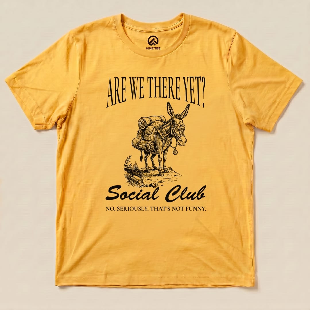 The "Are We There Social Club Shirt" features a humorous graphic of a donkey with camping gear, printed on a yellow graphic t-shirt.
