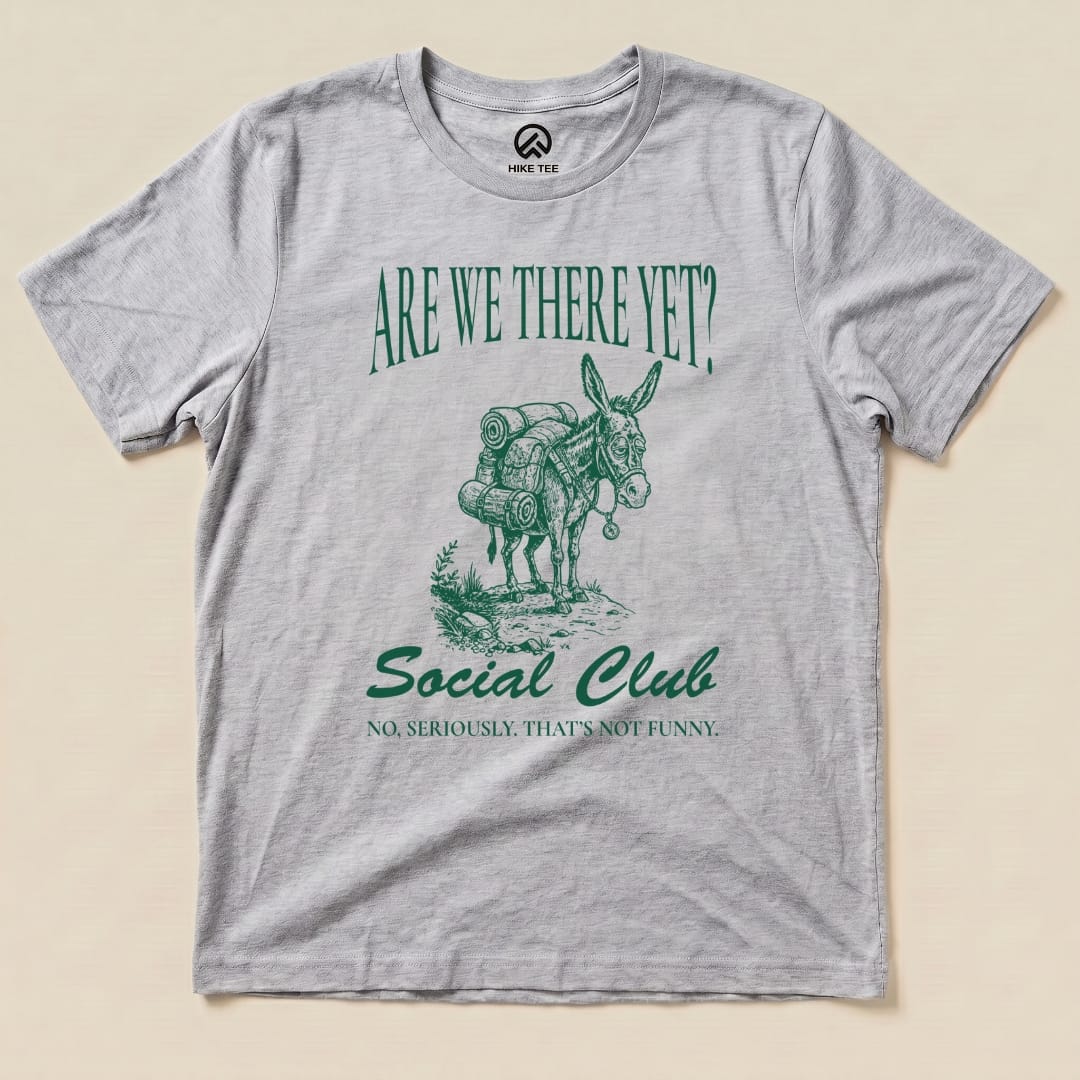 A gray graphic t-shirt features a packed donkey and the text "Are We There Yet? Social Club" with a humorous tagline below.