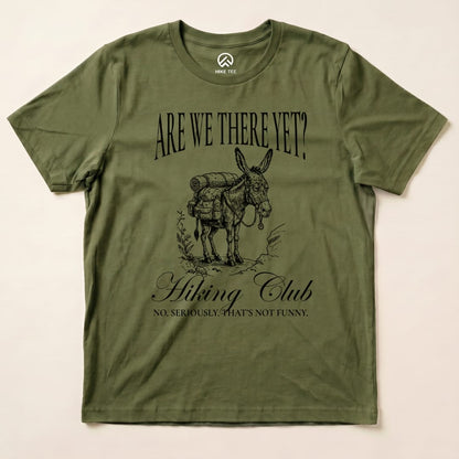 Olive green graphic t-shirt featuring a donkey with a backpack, labeled "Are We There Yet? Hiking Club" with the slogan below.