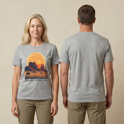 A woman is posing in a gray graphic t-shirt featuring a sunset over Badlands National Park with buffalo silhouettes.