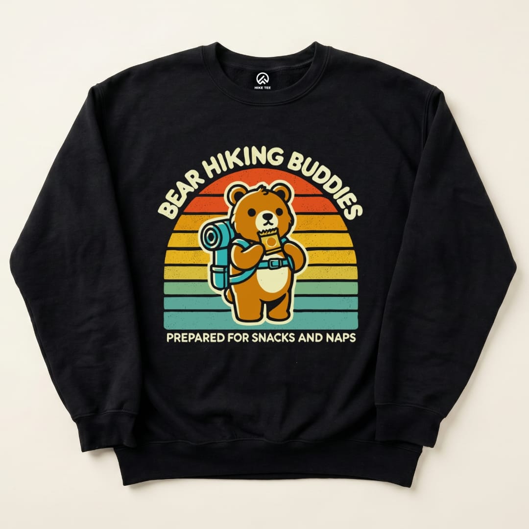 The Bear Hiking Buddies Sweatshirt features a cute bear with a backpack, holding snacks against a colorful retro background.