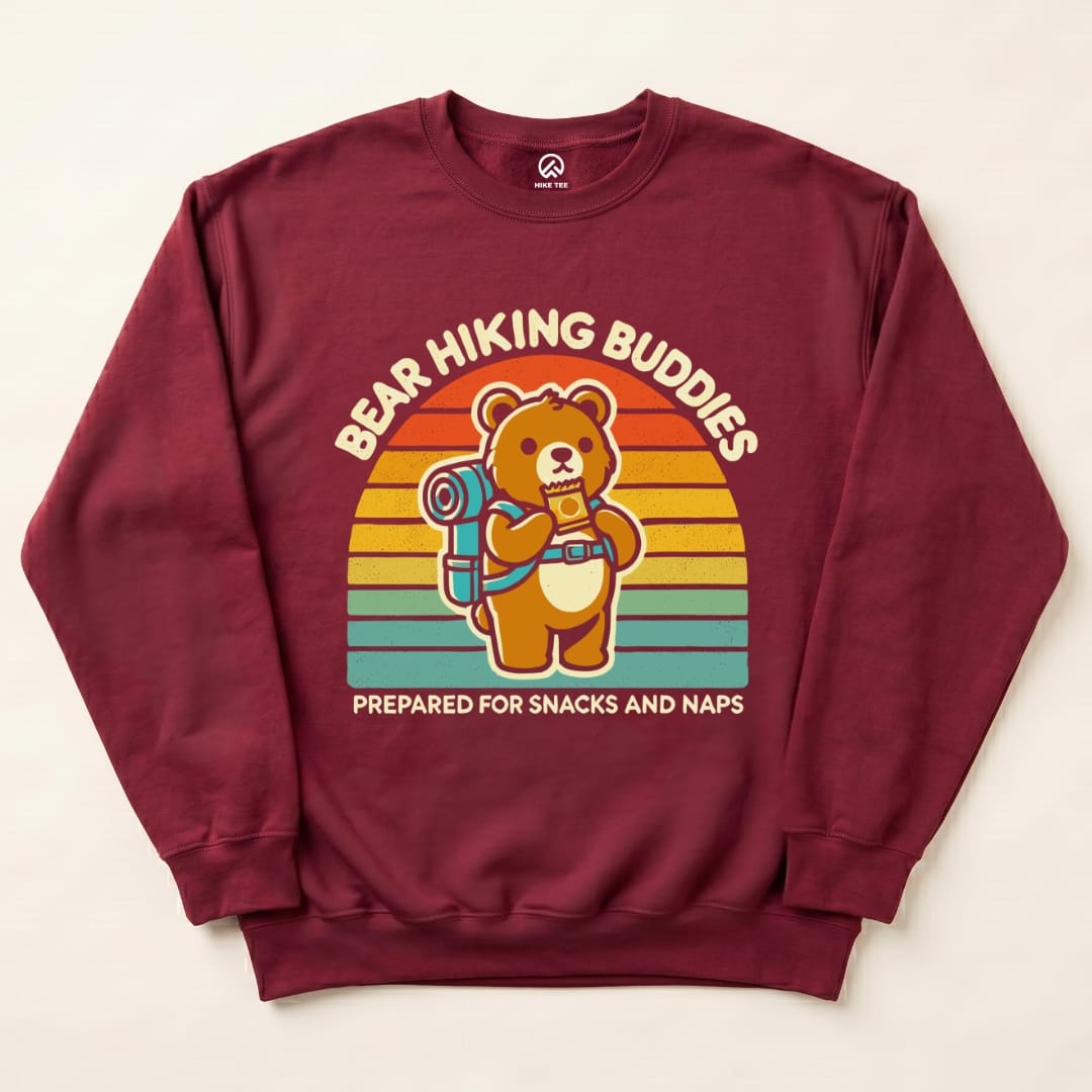 The Bear Hiking Buddies Sweatshirt features a cute bear with a backpack holding a snack, set against a retro-style rainbow background.