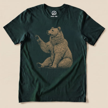 A graphic t-shirt featuring a bear in a sitting position, shown with the text "Bear Is Watching Shirt" in a playful design.