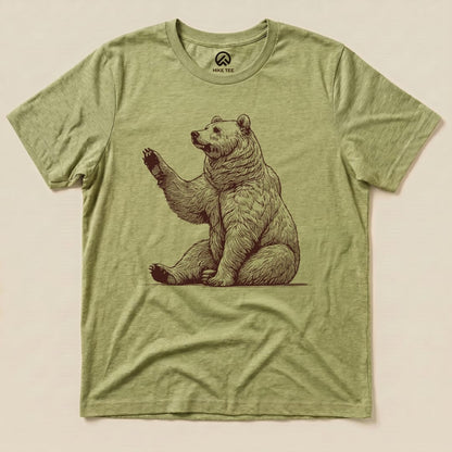A graphic t-shirt in olive green featuring a detailed illustration of a bear waving, titled "Bear is Watching Shirt.