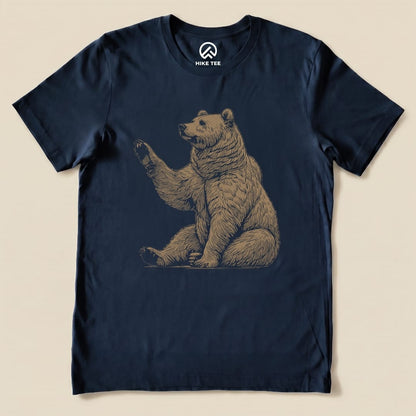 A graphic t-shirt featuring a waving bear design in a beige color on a navy blue background, labeled as the "Bear Is Watching Shirt.
