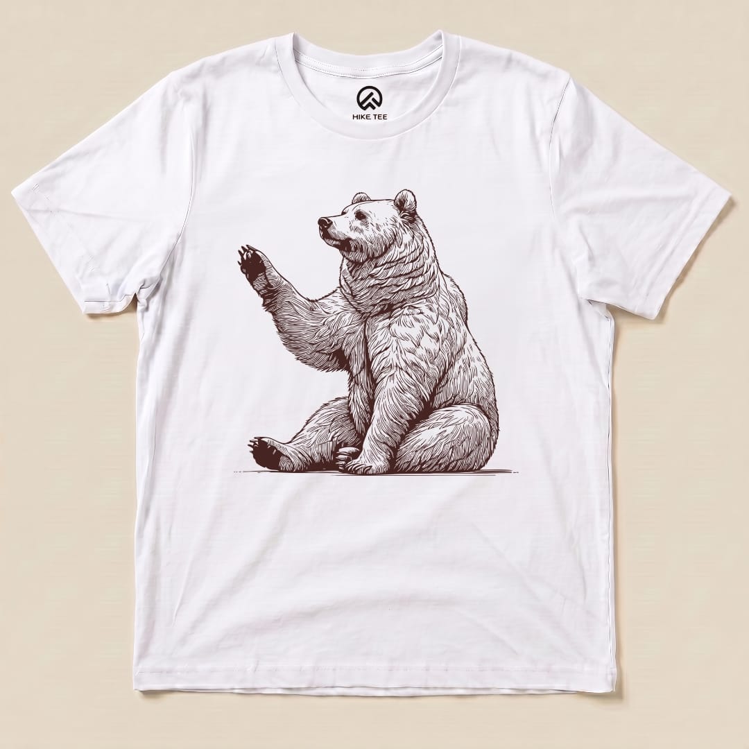 The Bear is Watching Shirt features a graphic of a sitting bear with a raised paw, printed on a white t-shirt.