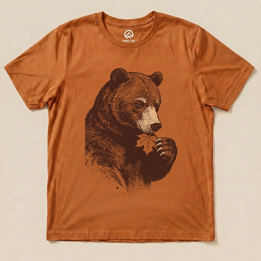 A graphic t-shirt featuring a bear holding a leaf, showcasing the "Bear With Leaf Shirt" design on an orange background.
