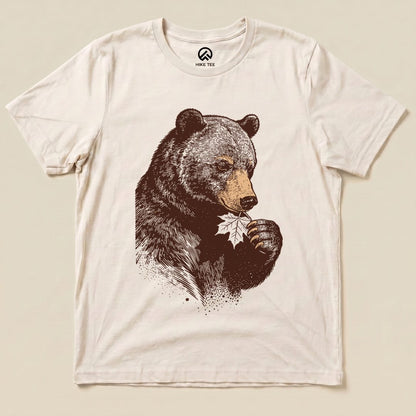 The graphic t-shirt features a bear holding a leaf, showcasing the humorous "Bear With Leaf Shirt" design in earthy tones.