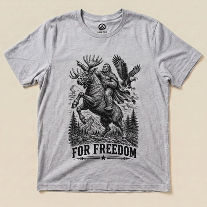 The graphic t-shirt features a striking illustration of Bigfoot riding a moose with the phrase "FOR FREEDOM" below.