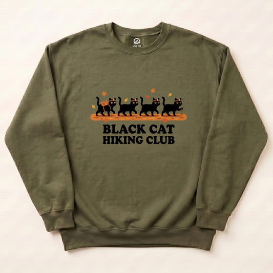 A graphic sweatshirt featuring playful black cats with the text "BLACK CAT HIKING CLUB" and autumn leaves in an olive green color.