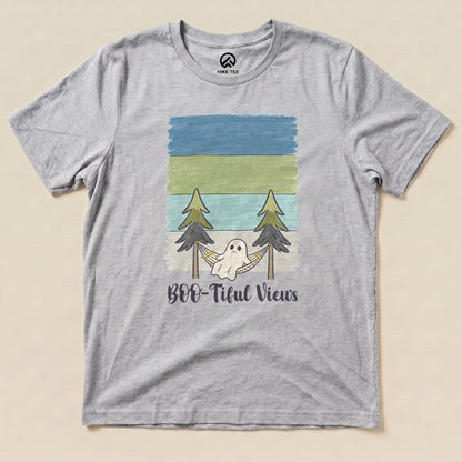 A gray graphic t-shirt featuring a whimsical ghost in a hammock between pine trees with the text "Boo-tiful Views.