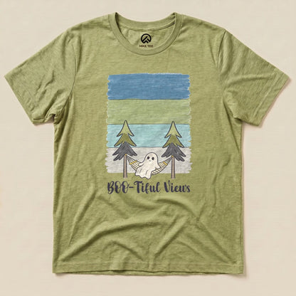 The Boo-tiful Views Shirt features a playful ghost in a hammock surrounded by trees, printed on a green graphic t-shirt.