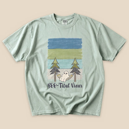 A graphic t-shirt featuring a ghost in a hammock between trees, with "Boo-tiful Views" printed below in playful lettering.