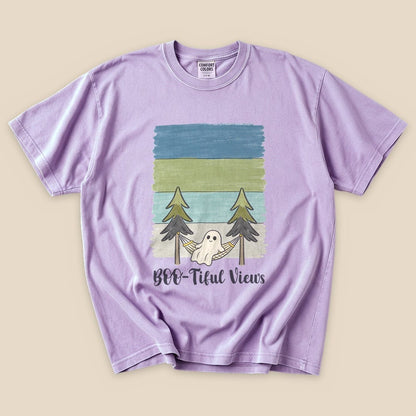 A purple graphic t-shirt features a playful design of a ghost in a hammock between trees, with the text "Boo-tiful Views".