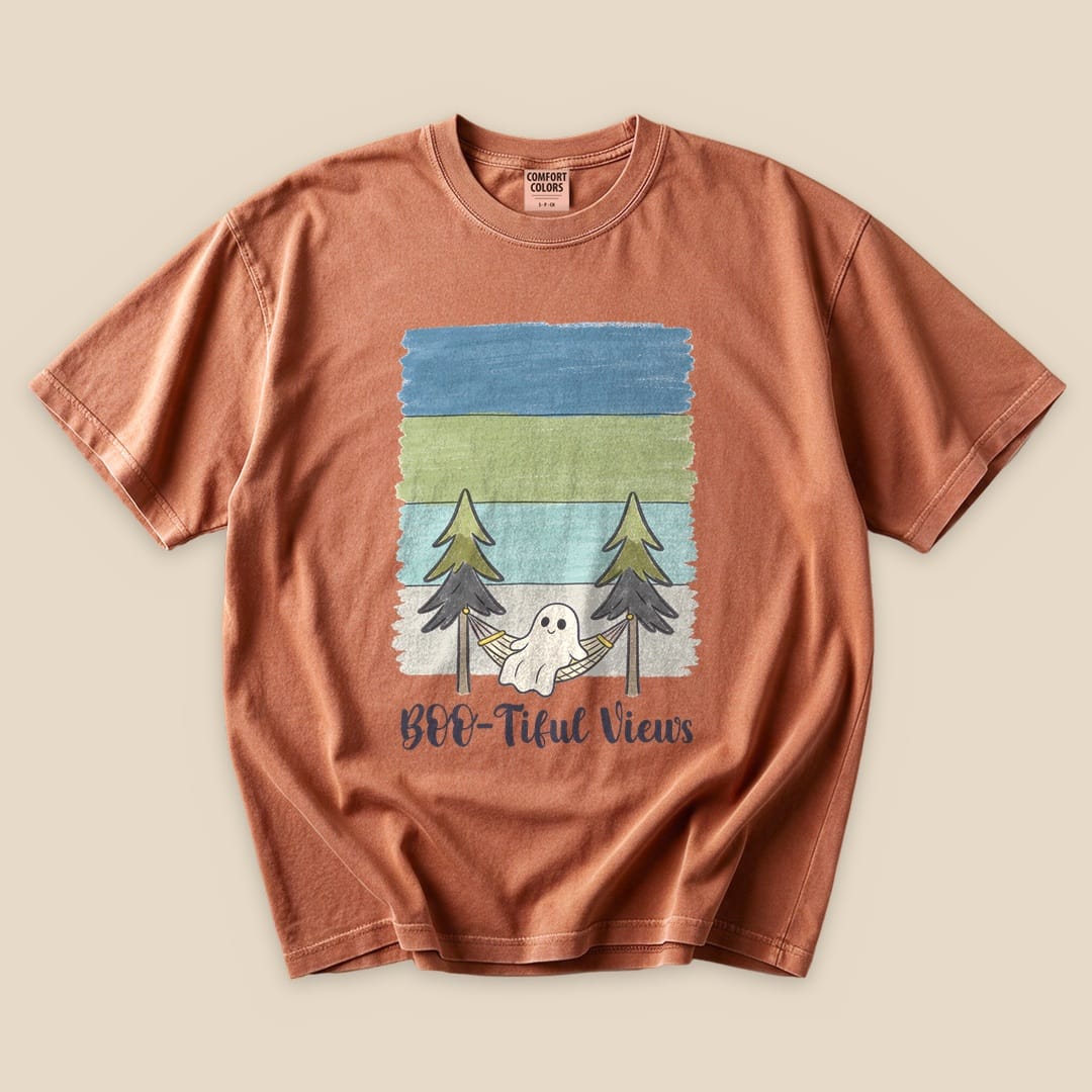 A flat lay of the Boo-tiful Views T-Shirt featuring a graphic of a ghost in a hammock between trees with the text "Boo-tiful Views.