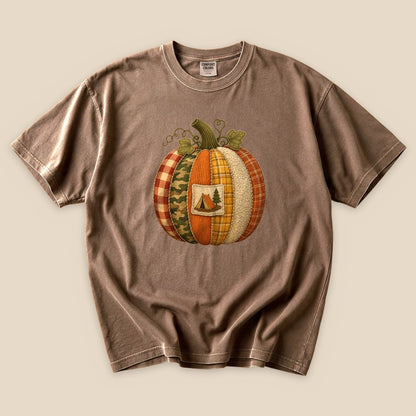 The Camp Pumpkin T-Shirt features a whimsical graphic of a patchwork pumpkin with a camping tent and tree design.