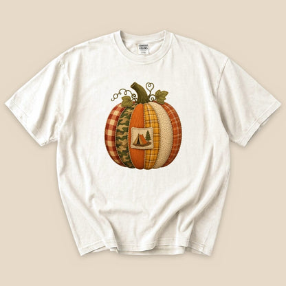 A Camp Pumpkin T-Shirt in cream features a colorful pumpkin design made of various fabrics and a small camping emblem.
