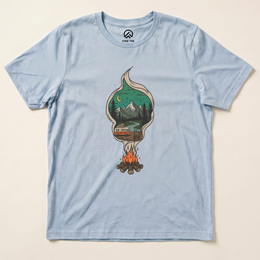A light blue graphic t-shirt features a campfire design with a scenic landscape and camper, labeled as the "Campfire Smoke Shirt.