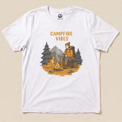 A graphic t-shirt featuring a cozy campfire scene, with the words "CAMPFIRE VIBES" above an illustrated hiker and dog.