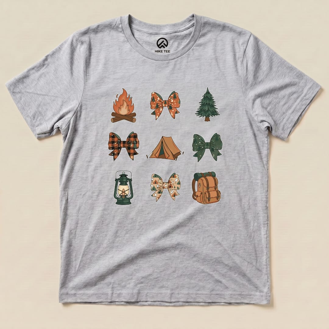 A graphic t-shirt featuring whimsical icons of campfires, bows, trees, and tents arranged in a fun pattern, named "Camping Bows Shirt.