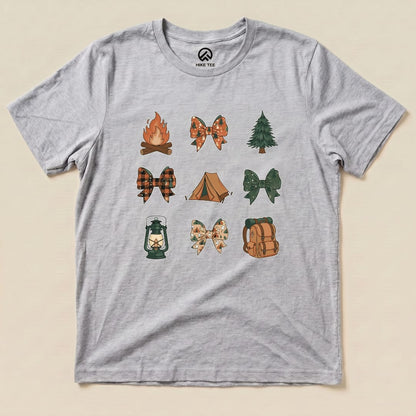 A graphic t-shirt featuring whimsical icons of campfires, bows, trees, and tents arranged in a fun pattern, named "Camping Bows Shirt.